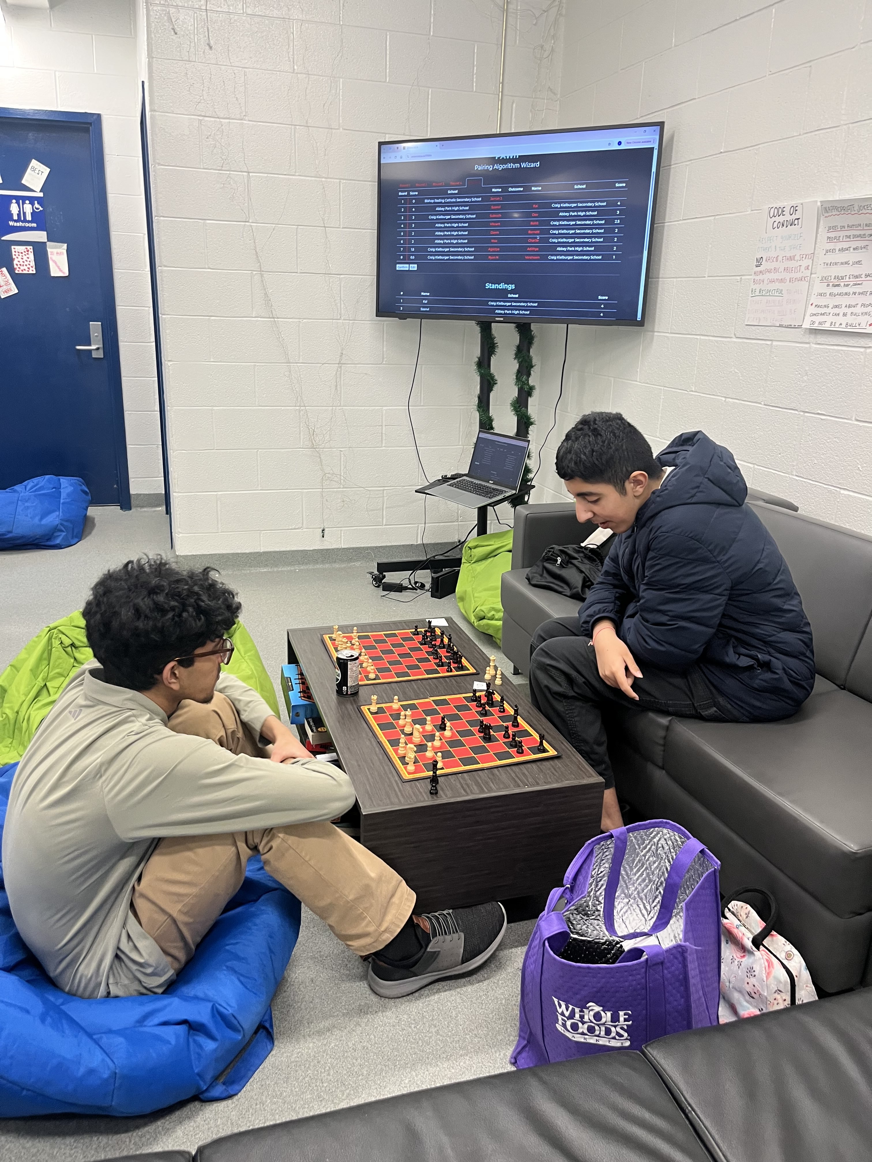2 highschool chess players shaking hands after a tense chess game